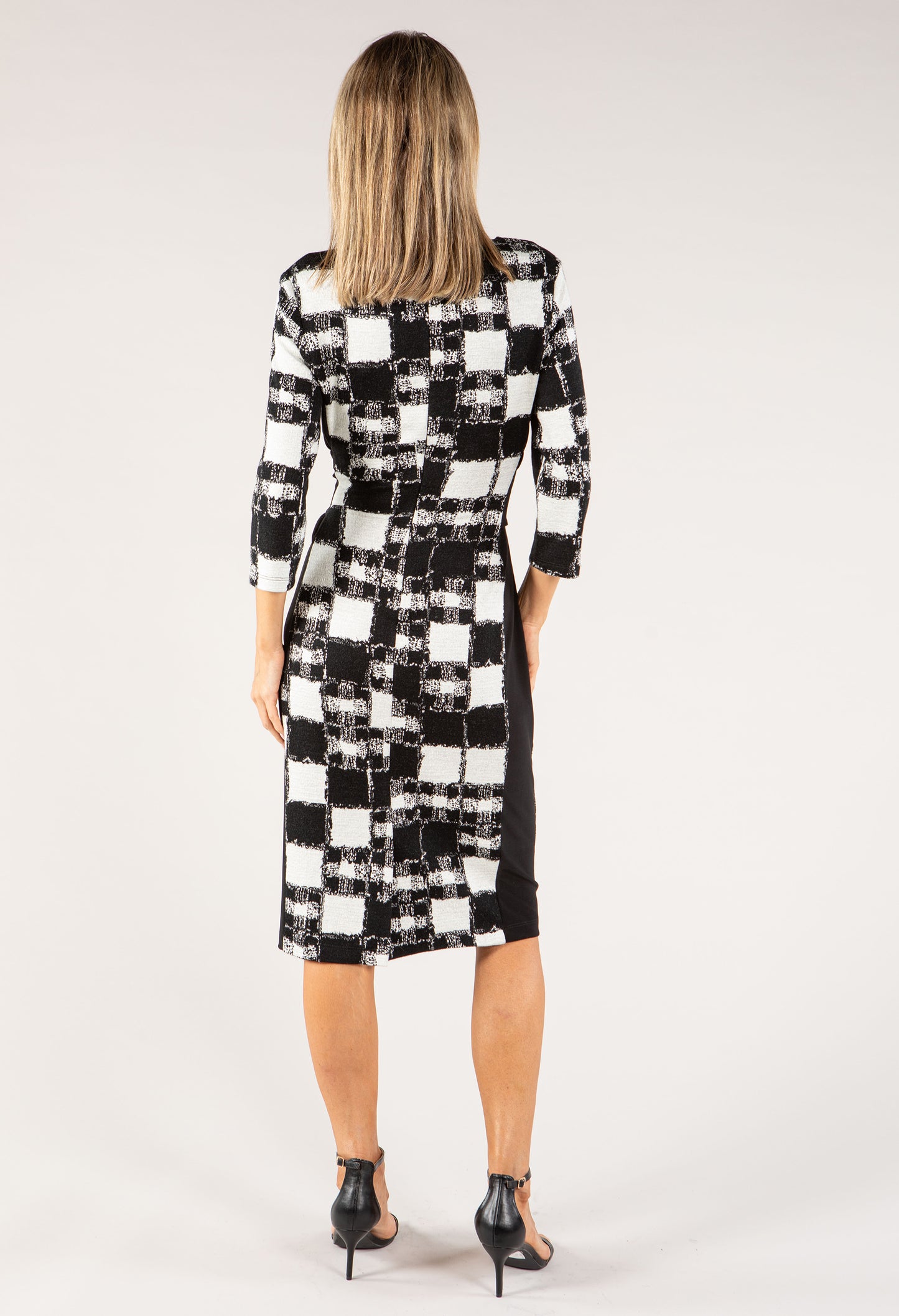 Woman wearing a black and white checkered dress on a white background