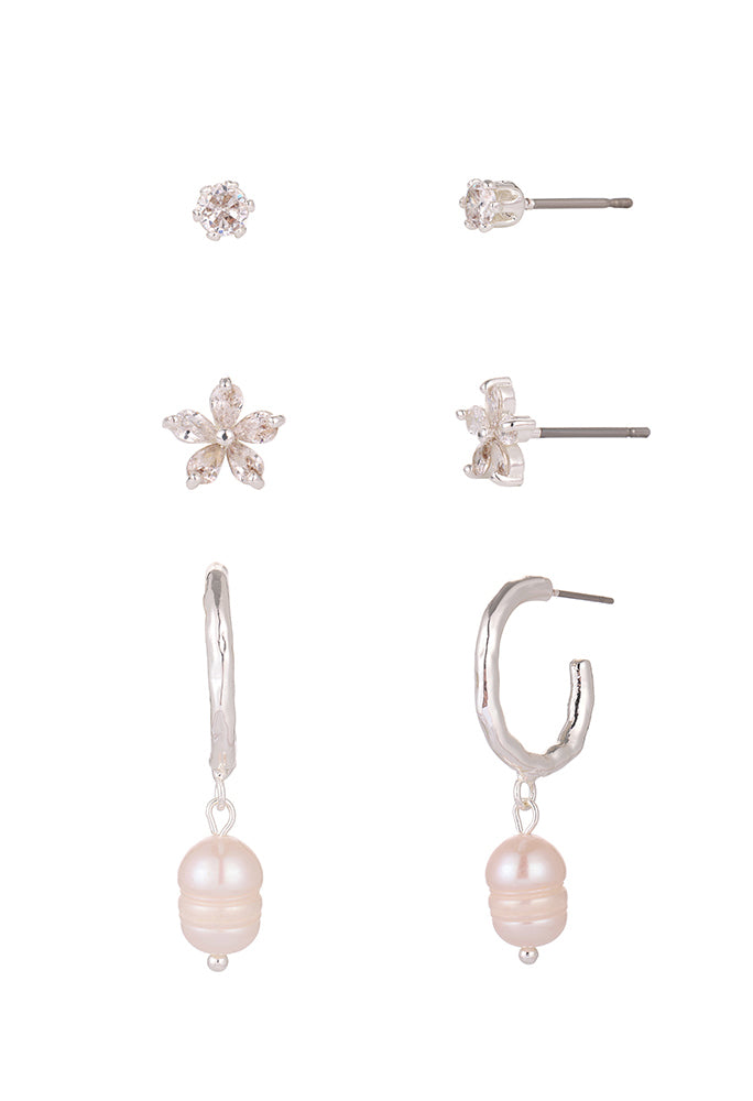 Set of earrings including floral, hoop with pearl, and other designs on a white background