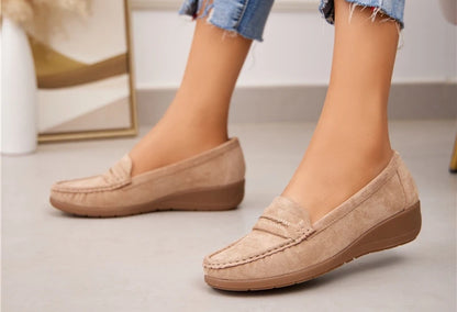 a pair of beige coloured faux suede loafers with wedge sole