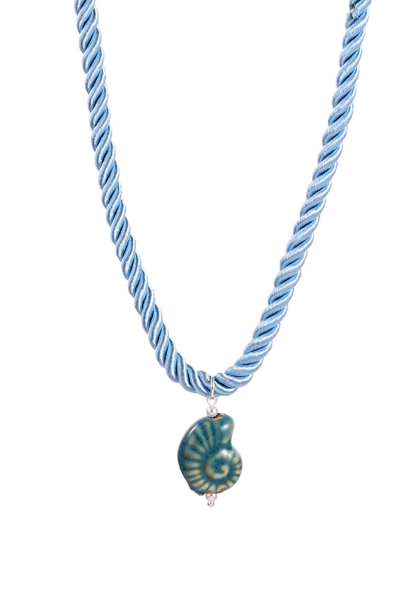 Blue twisted cord necklace with a green and blue nautilus shell pendant on a white background