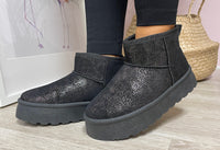 A pair of slip-on ankle boots with a shimmer finish in a color best described as beige-black, featuring a round toe and a platform sole.