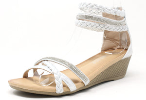 A white-colored wedge sandal with triple ankle straps and a rhinestone-embellished strap across the foot. The sandal features a open toe design and a comfort sole.