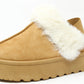 A camel flatform slip on boot with fur lining around the top edge and an elastic ankle strap.
