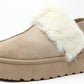 A beige flatform slip on boot with fur lining around the top edge and an elastic ankle strap.