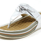 A silver coloured sandal with a thong style strap and a flat sole.