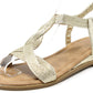 gold sandal with braided design on a white background