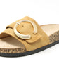 Beige sandal with a circular buckle on a white background