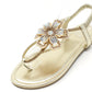 Gold sandal with decorative flower on a white background