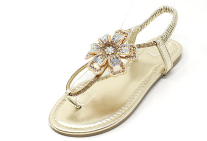 Gold sandal with decorative flower on a white background
