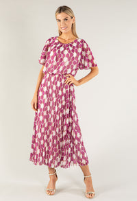 Woman wearing a pink and white patterned dress on a plain background