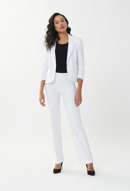Woman wearing a white suit with a black top on a white background