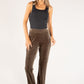 Woman wearing brown velvet pants and a black top on a white background