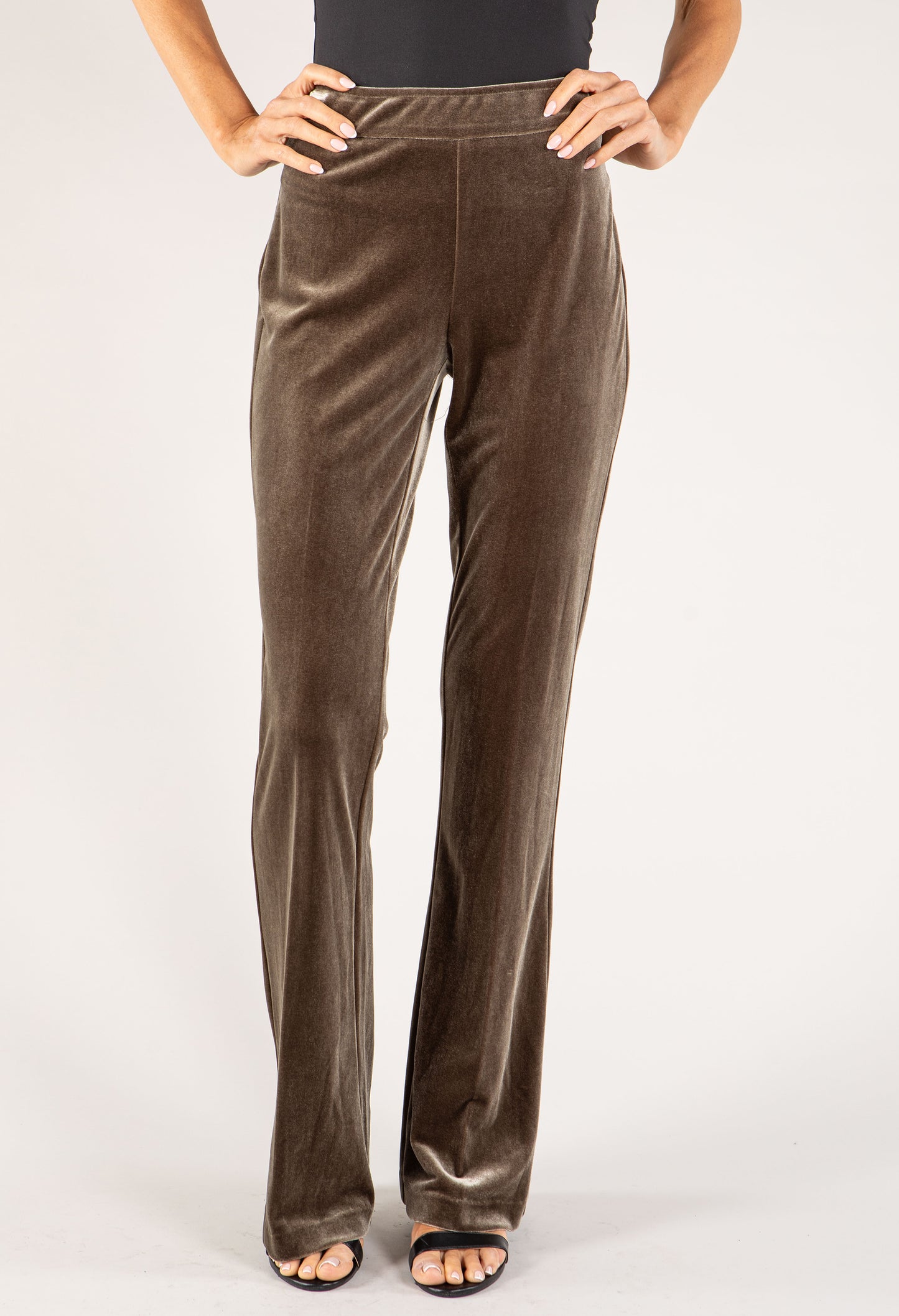 Brown velvet pants worn by a person on a white background