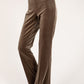 Brown velvet pants worn by a person on a white background