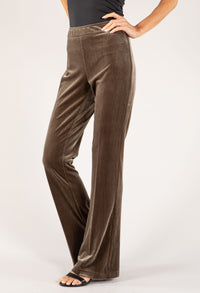 Brown velvet pants worn by a person on a white background