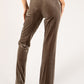 Brown velvet pants worn by a person on a white background
