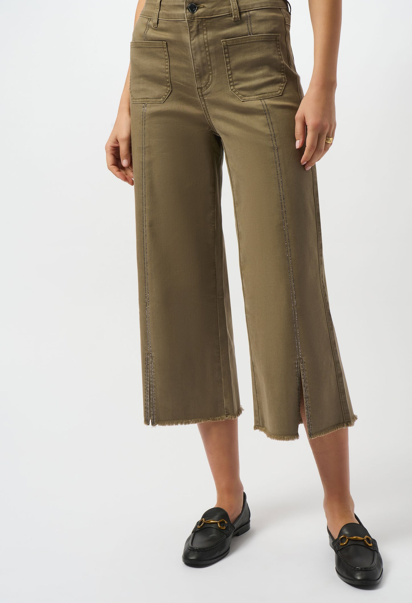Person wearing olive green wide-leg pants on a white background