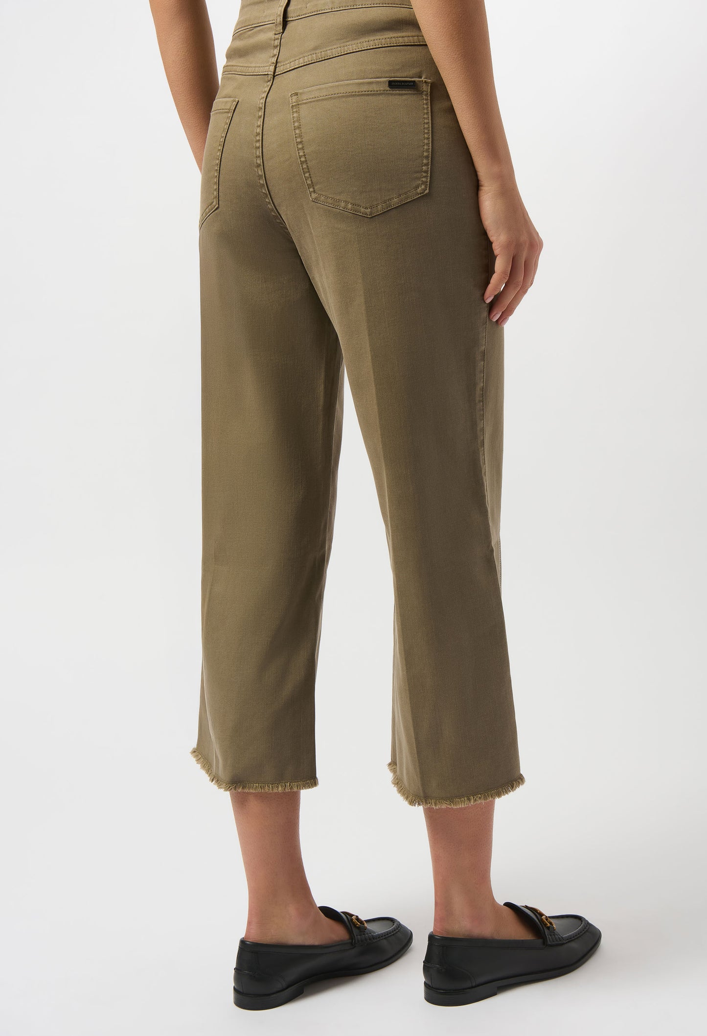 Person wearing olive green pants on a white background