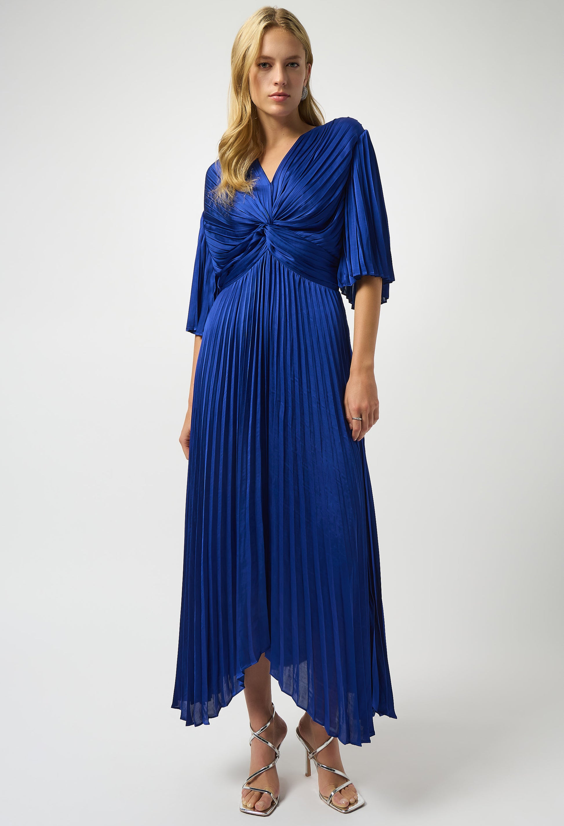 Woman wearing a blue pleated dress on a white background