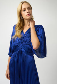 Woman wearing a blue pleated dress with a white background