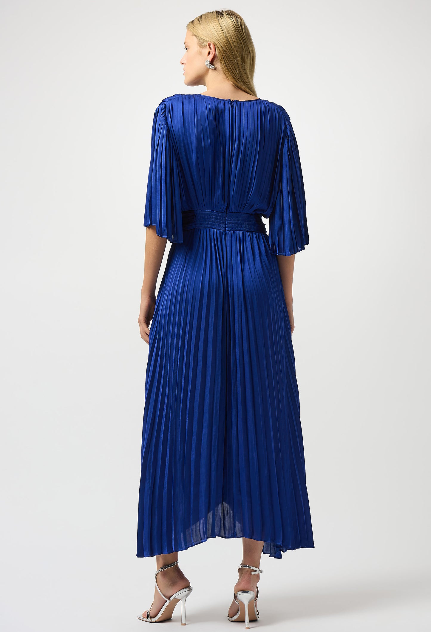 Woman wearing a blue pleated dress on a white background