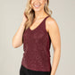 Woman wearing a burgundy sequin tank top against a plain background