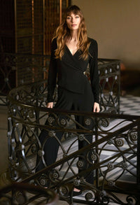 Woman in a black outfit standing on a decorative staircase