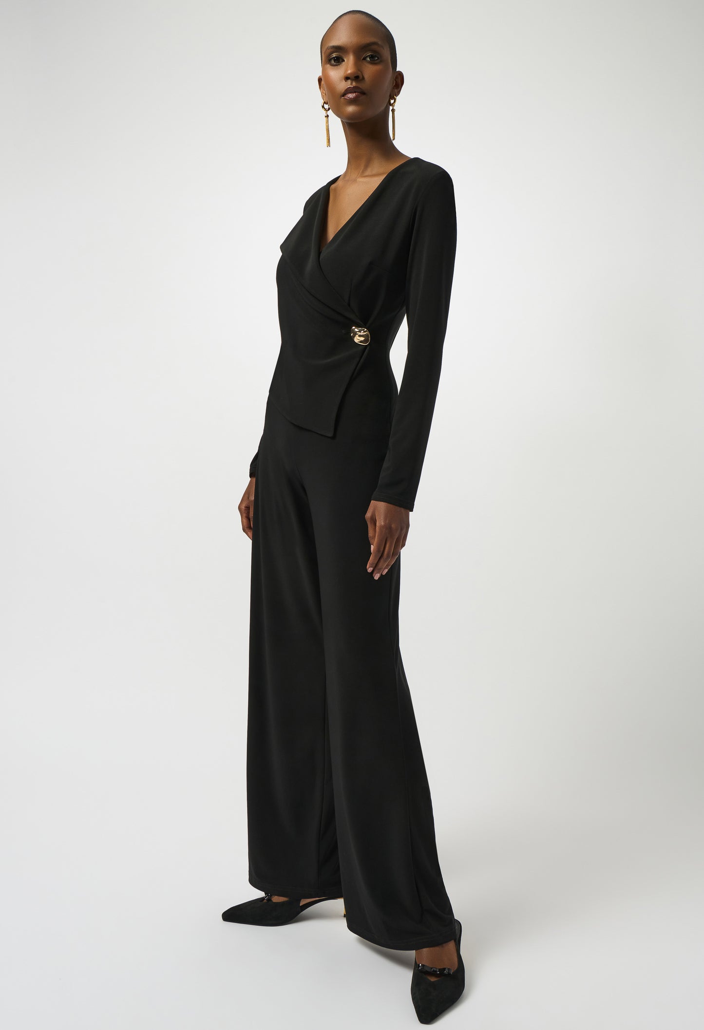 Woman wearing a black jumpsuit with a white background