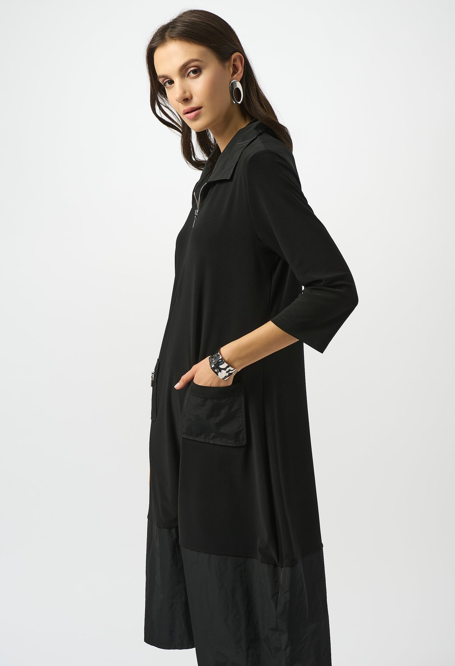 Woman wearing a black coat with a white background