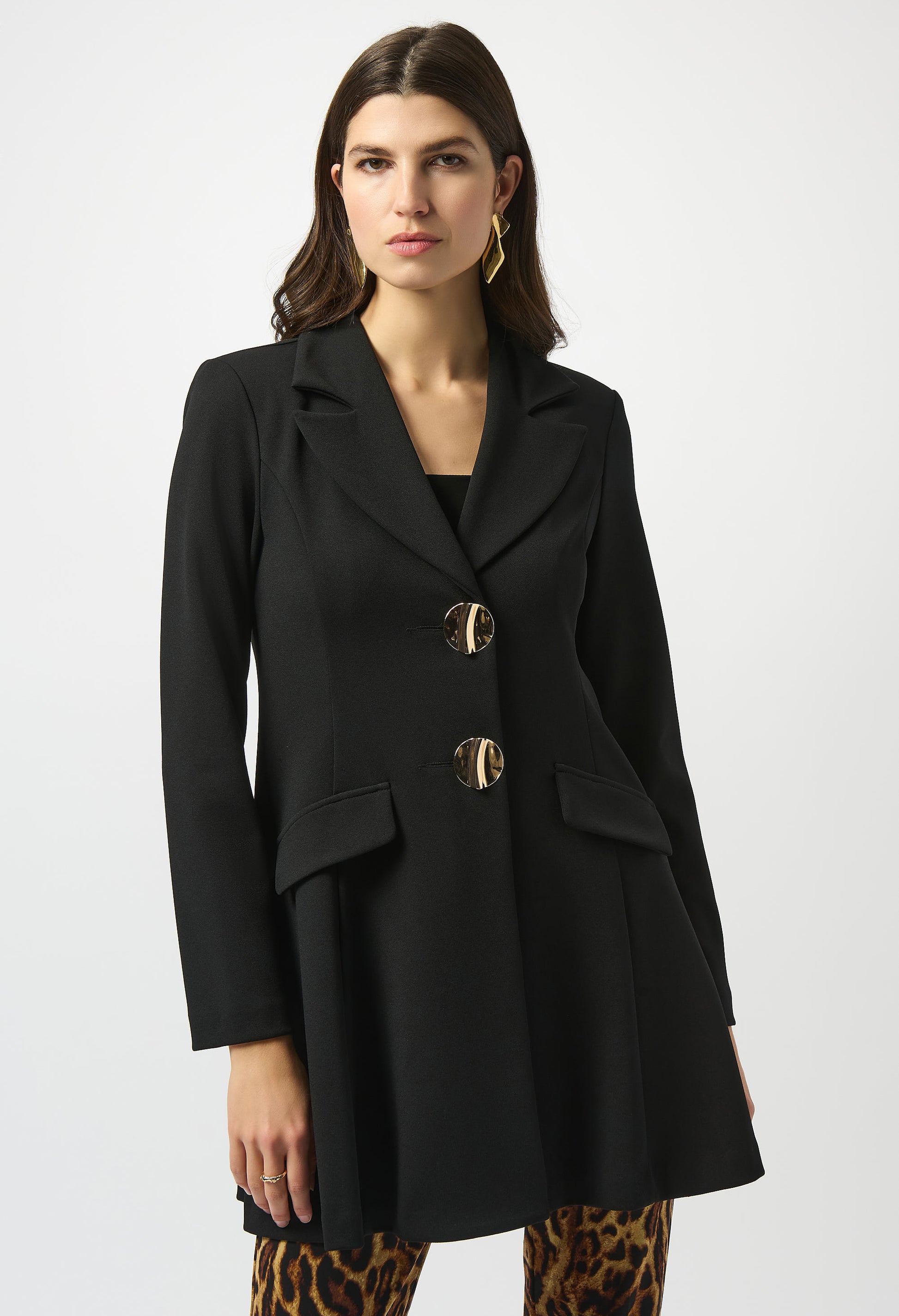 Woman wearing a black coat with gold buttons on a white background