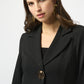 Woman wearing a black coat with gold buttons on a white background