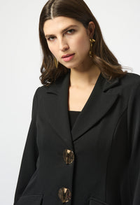 Woman wearing a black coat with gold buttons on a white background