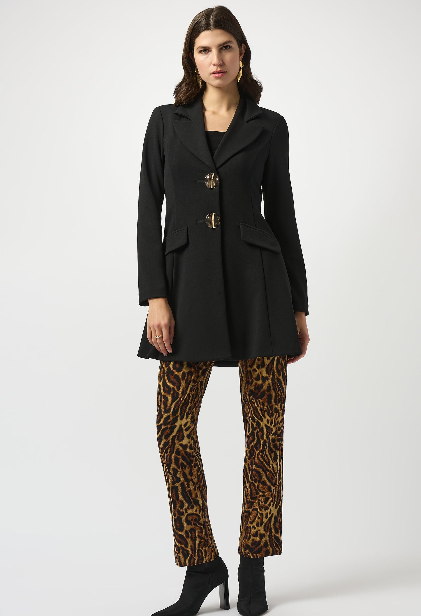 Woman wearing a black coat and leopard print pants on a white background