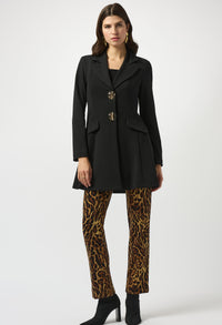 Woman wearing a black coat and leopard print pants on a white background