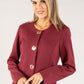 Woman wearing a burgundy jacket with button details on a white background