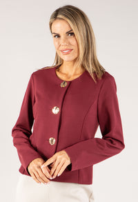 Woman wearing a burgundy jacket with button details on a white background