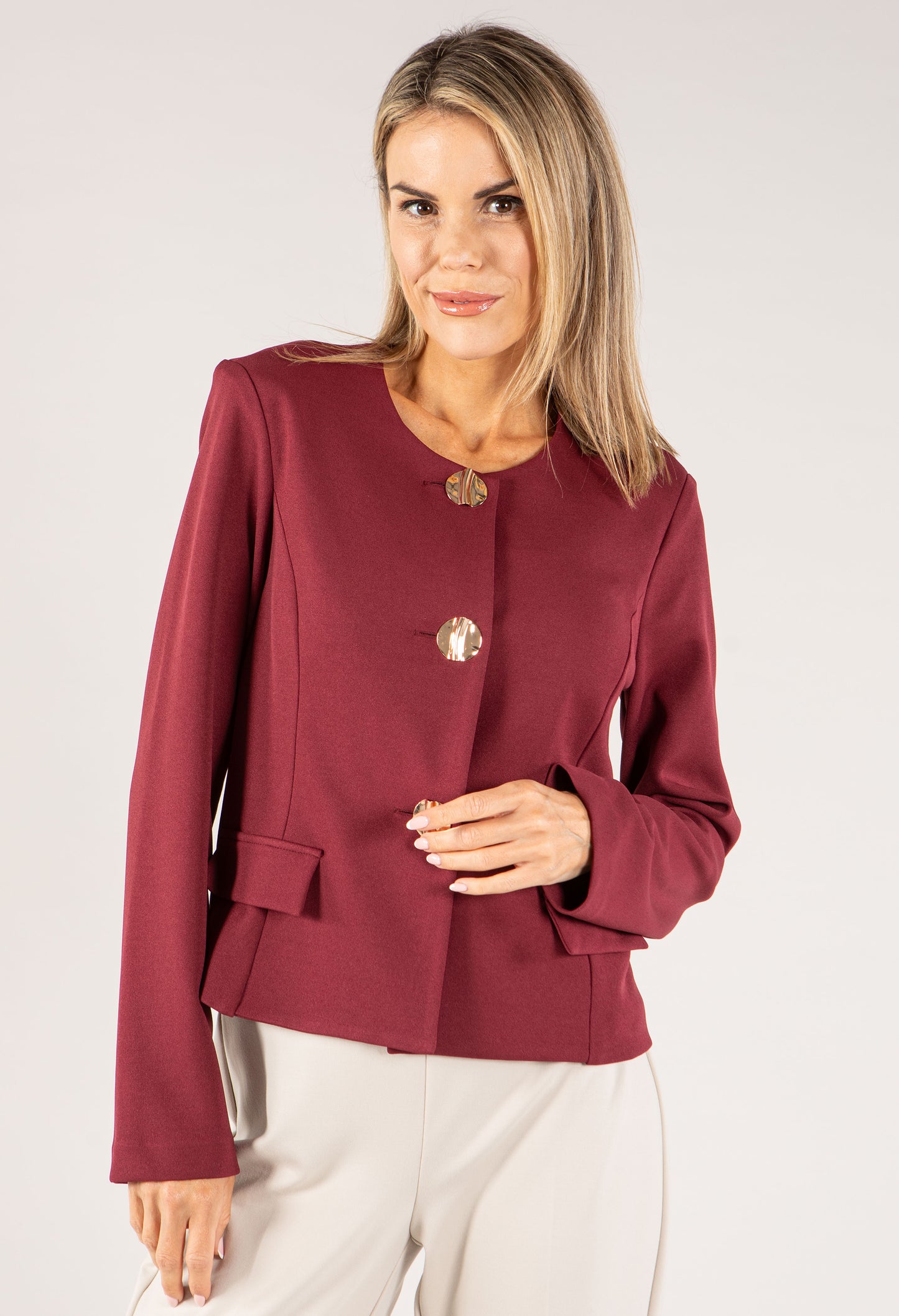 Woman wearing a burgundy blazer with a white background