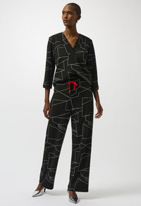 Woman wearing a black geometric patterned outfit with a red belt on a white background