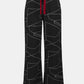 Black pants with white abstract pattern and red drawstring on a white background