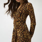 Woman wearing a leopard print dress on a white background