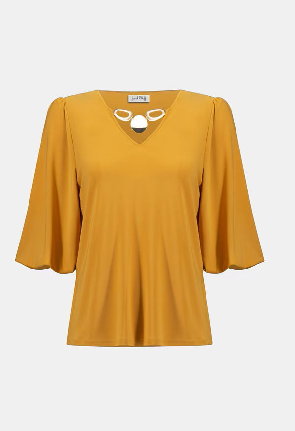 Yellow blouse with a white label on a light gray background