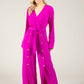 woman wearing magenta jumpsuit with gold buttons