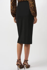 Person wearing a black pencil skirt with leopard print top and shoes on a white background