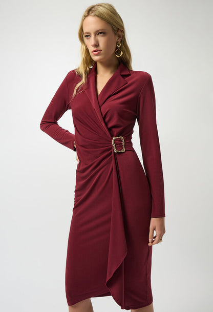 Woman wearing a burgundy dress with a belt on a white background
