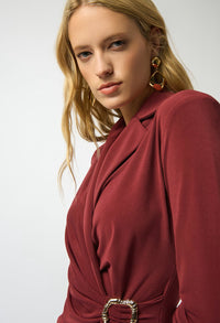 Woman wearing a red coat with a gold buckle on a white background
