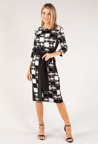 Woman wearing a black and white checkered dress on a white background