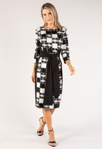 Woman wearing a black and white checkered dress on a white background