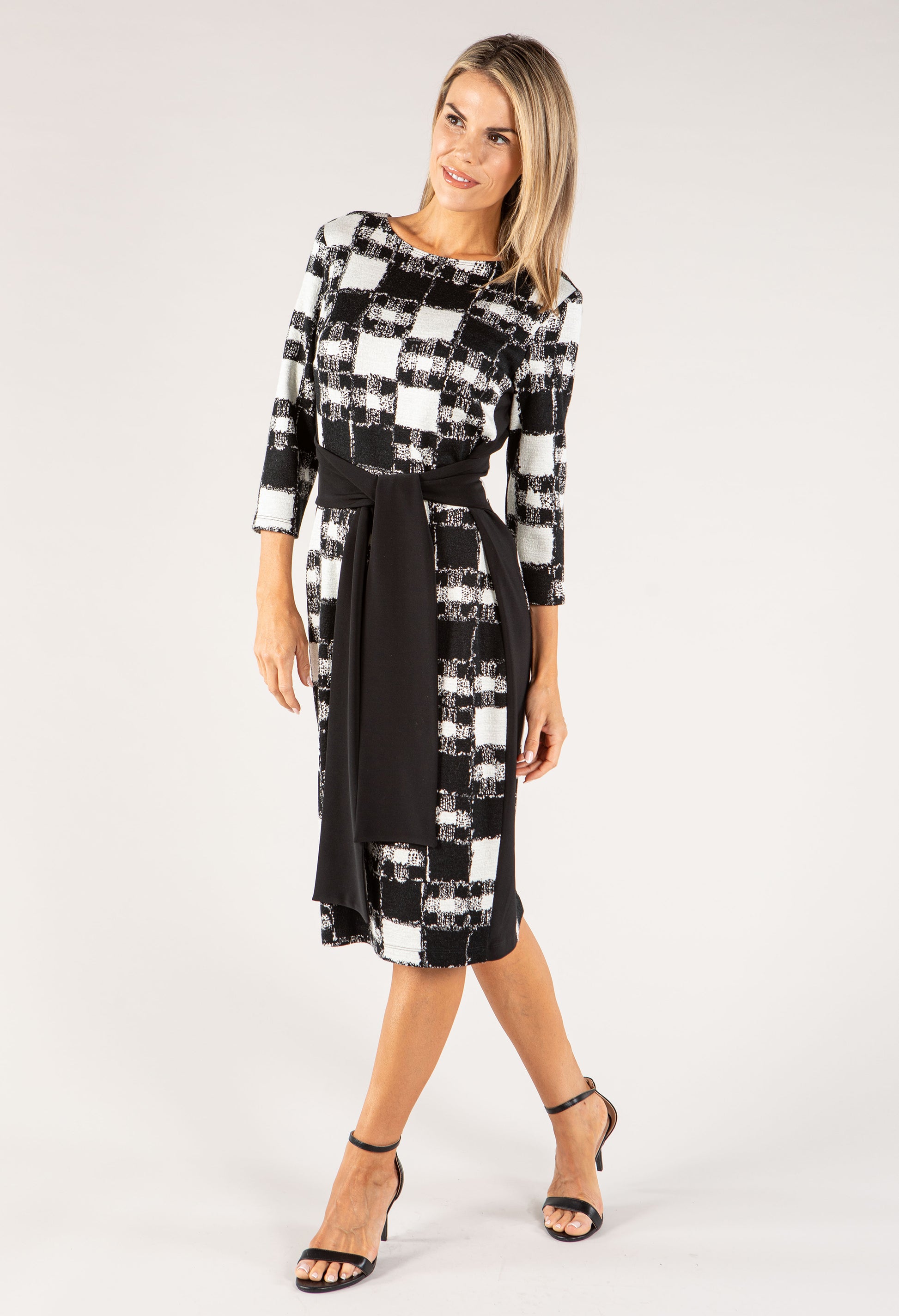 Woman wearing a black and white checkered dress on a white background