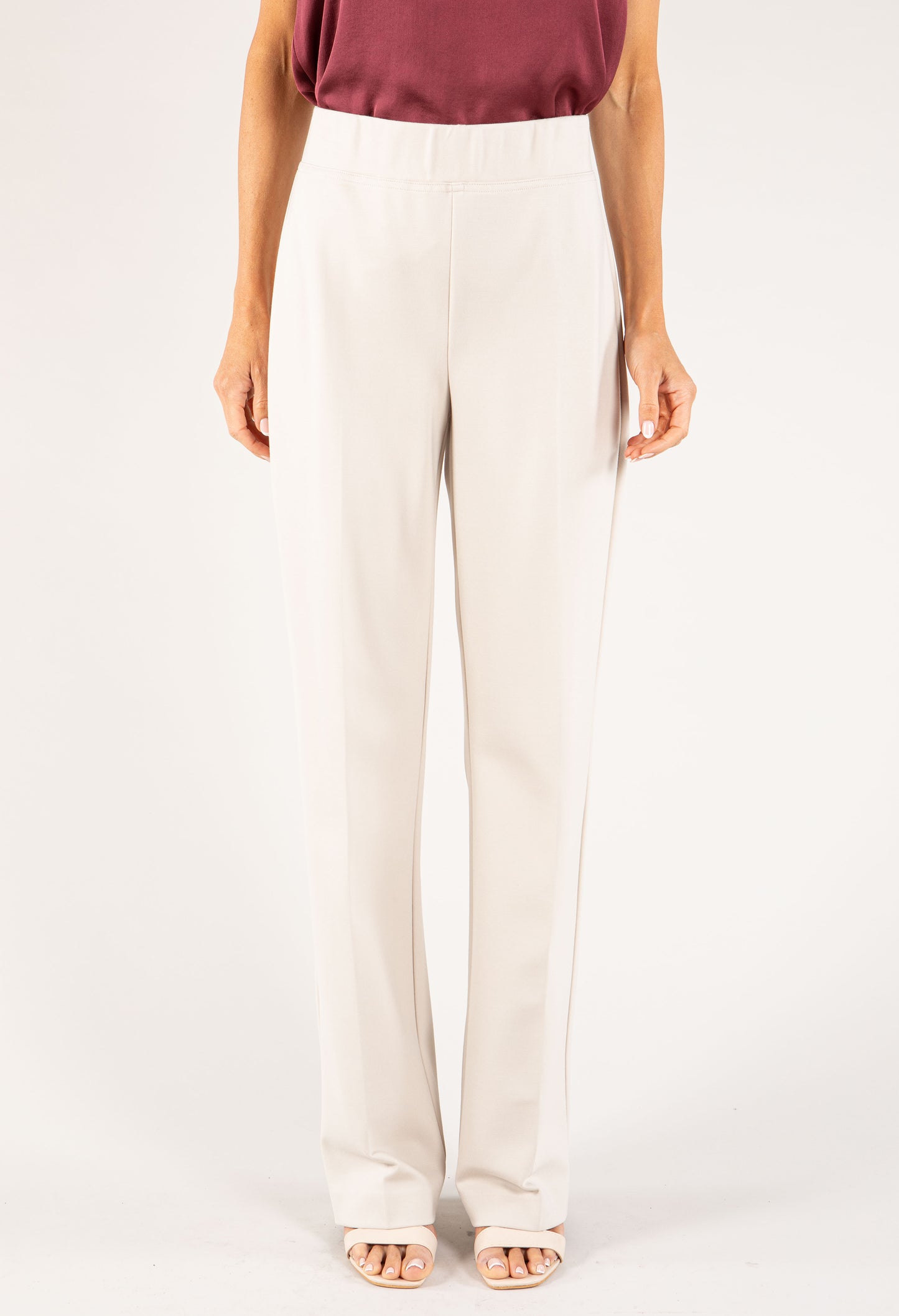 Person wearing white pants on a plain background