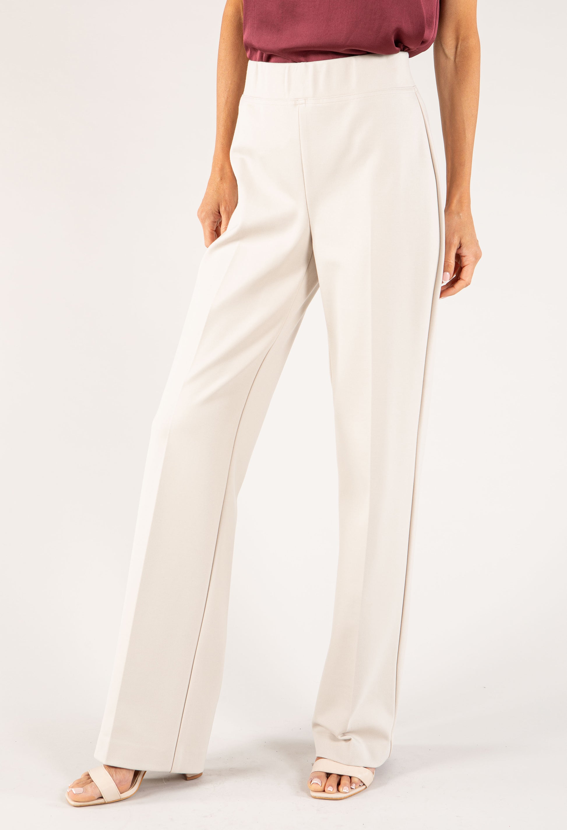 White pants worn by a person on a white background